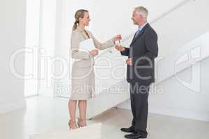 Smiling estate agent handing over keys to customer