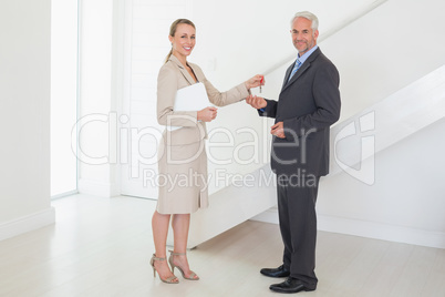 Smiling estate agent handing over keys to customer