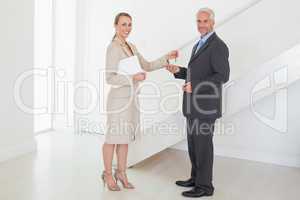 Smiling estate agent handing over keys to customer