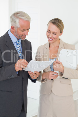 Smiling estate agent going over contract with customer