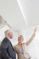 Smiling estate agent showing ceiling to potential buyer