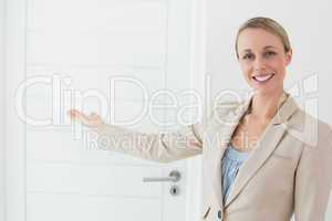 Smiling estate agent showing door to camera
