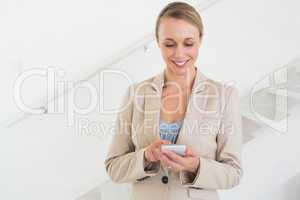 Smiling estate agent sending a text message