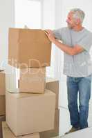 Smiling man looking at cardboard moving boxes