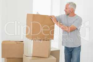 Smiling man looking at cardboard moving boxes