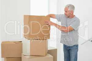 Smiling man looking at cardboard moving boxes