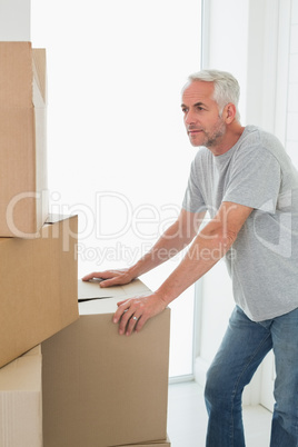 Thoughtful man looking at cardboard moving boxes