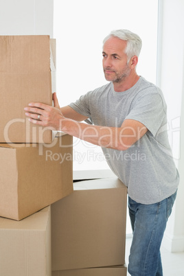 Thoughtful man looking at cardboard moving boxes