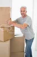 Happy man moving cardboard moving boxes