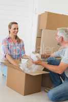 Happy couple unpacking cardboard moving boxes