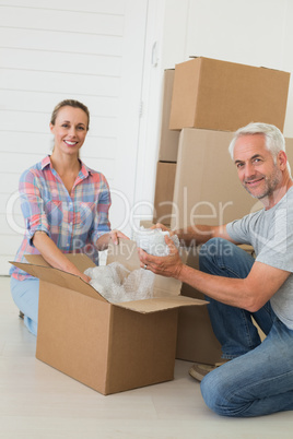 Happy couple unpacking cardboard moving boxes