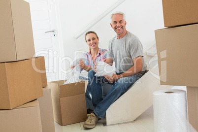 Happy couple unpacking cardboard moving boxes