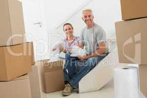 Happy couple unpacking cardboard moving boxes