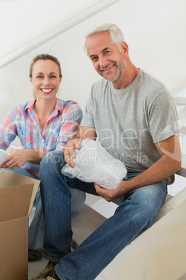 Happy couple unpacking cardboard moving boxes