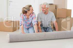 Happy couple rolling out new rug