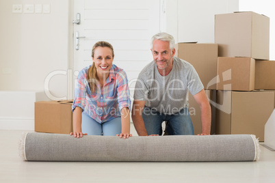 Happy couple rolling out new rug