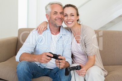 Happy couple having fun on the couch playing video games