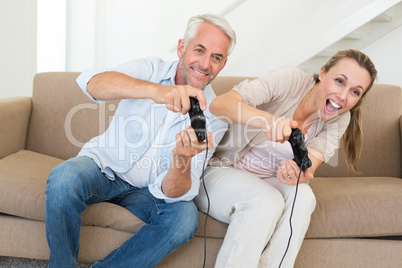 Happy couple having fun on the couch playing video games