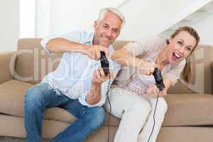 Happy couple having fun on the couch playing video games