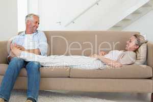 Caring man giving his partner a foot rub on the couch