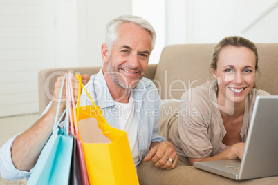 Happy couple shopping online on the couch