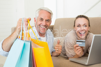 Happy couple shopping online on the couch