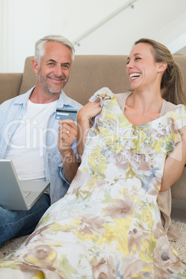 Happy couple shopping online on the couch