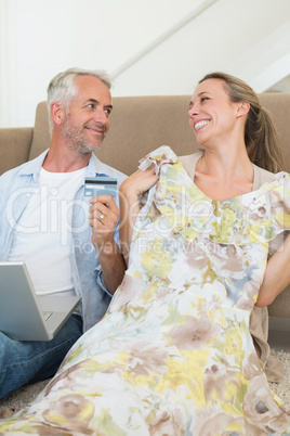 Happy couple shopping online on the couch