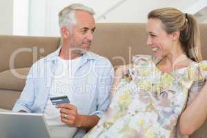 Happy couple shopping online on the couch