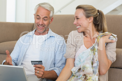 Happy couple shopping online on the couch