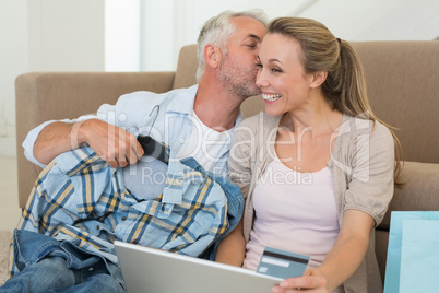 Happy couple shopping online on the couch