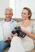 Happy couple viewing their photos on the laptop