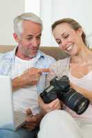 Happy couple viewing their photos on the laptop