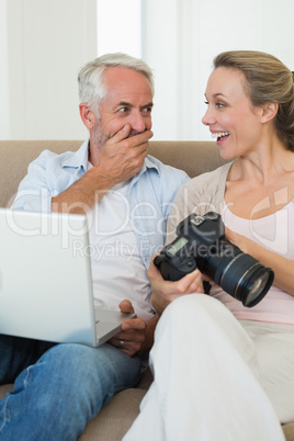 Happy couple viewing their photos on the laptop