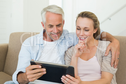 Happy couple using tablet pc together on the couch