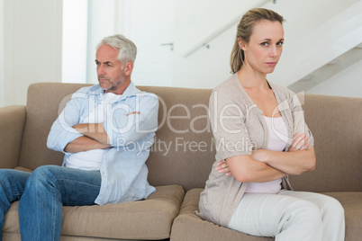 Angry couple sitting on couch not talking to each other