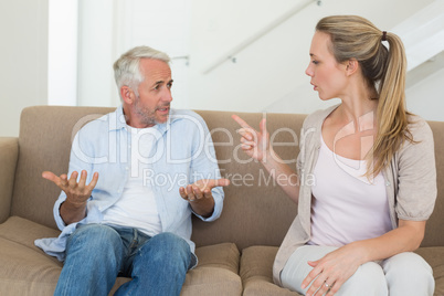 Angry couple sitting on couch arguing