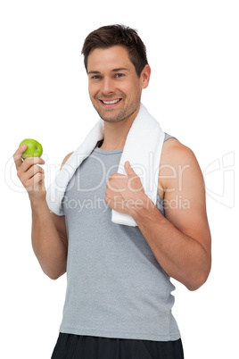 Portrait of a smiling fit young man with apple standing