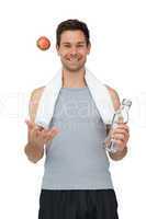 Smiling fit young man with apple and water bottle