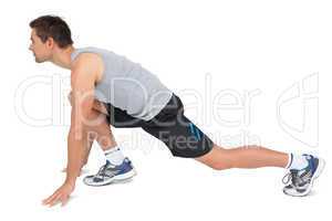 Side view of a young man in ready to run posture