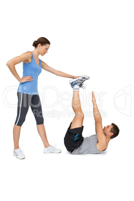 Female trainer assisting man with exercises