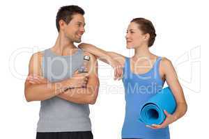 Fit young couple with exercise mat and water bottle