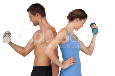 Fit young couple exercising with dumbbells