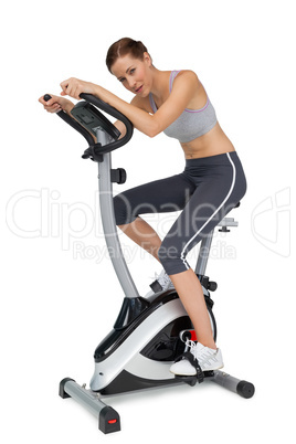 Side view of a beautiful young woman on stationary bike