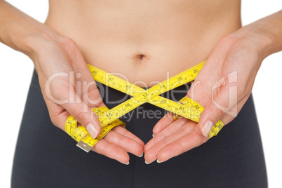 Close-up mid section of a woman measuring waist