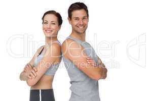 Portrait of a happy fit young couple with hands crossed