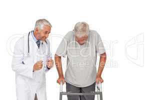 Doctor with senior man using walker