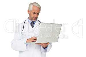 Concentrated male doctor using laptop