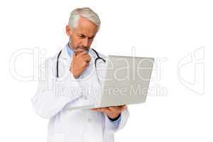 Concentrated male doctor using laptop