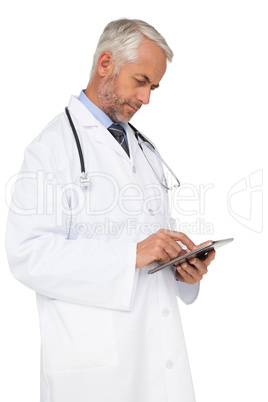 Concentrated male doctor using digital tablet